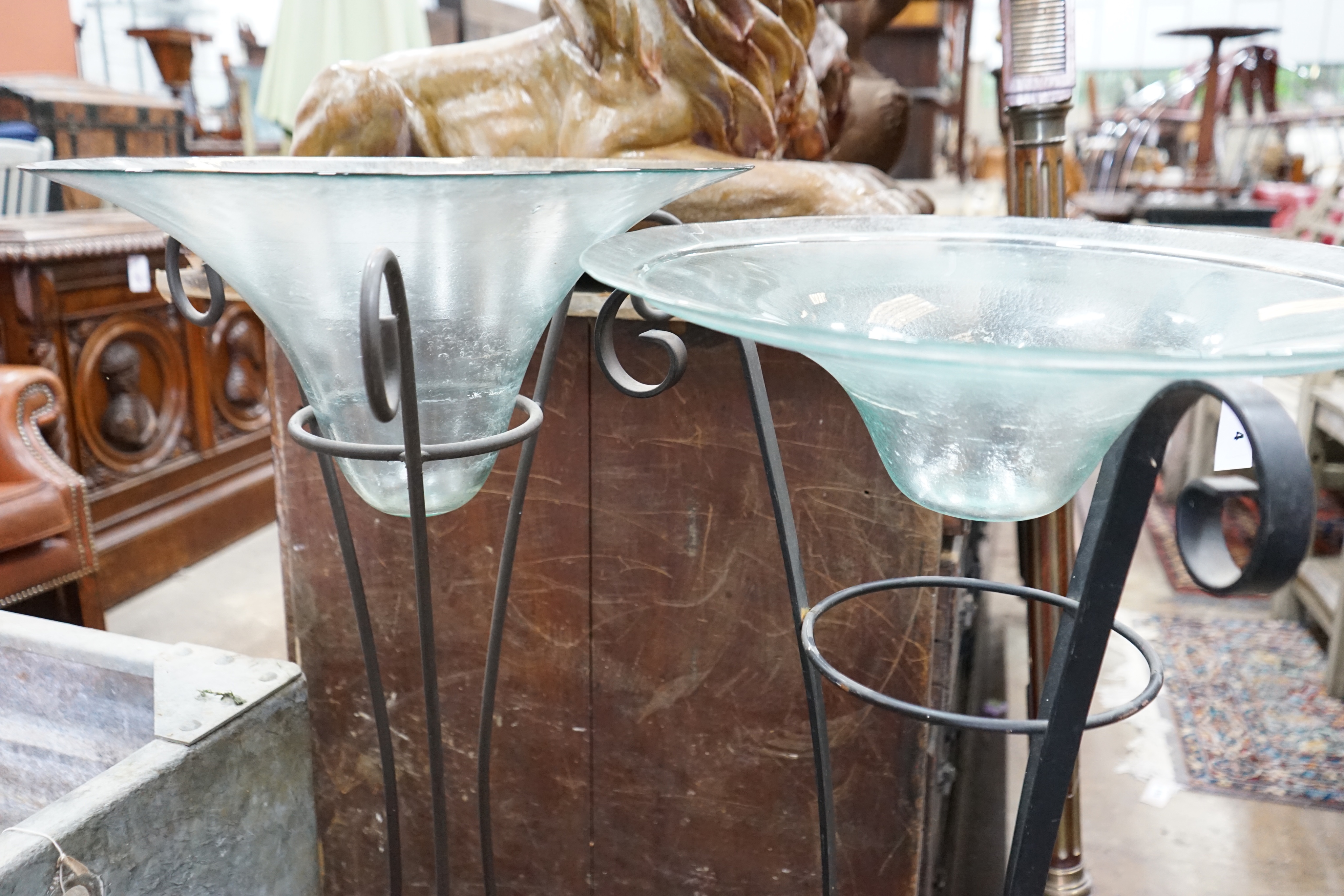 A near pair of circular glass bowls on wrought iron stands, tallest 103cm